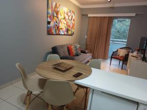 een keuken en een woonkamer met een tafel en stoelen bij Flat Águas da Serra - com acesso ao rio in Rio Quente