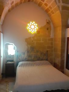 レッチェにあるVico del Sole b&bのベッドルーム1室(ベッド1台、上部にライト付)