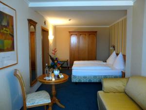 a hotel room with two beds and a table and a couch at Gasthaus Weingut Stahl in Oberwesel