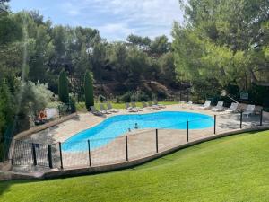 a large swimming pool with lounge chairs at LES CISTES in Mallemort