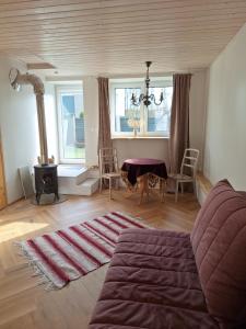 a living room with a couch and a table and two windows at Tiigi apartment in Haapsalu