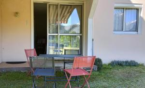 Una mesa y cuatro sillas frente a una casa. en Appartement T2, en Argelès-Gazost 1 foto más