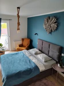 a bedroom with a bed with a blue wall at Przytulny Apartament Słowackiego in Wągrowiec