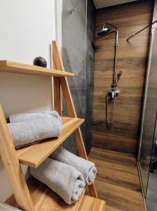 a bathroom with wooden shelves and a shower at Przytulny Apartament Słowackiego in Wągrowiec