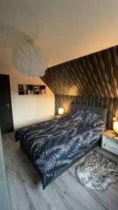 a bedroom with a bed with a black comforter at Maison Gite Chez Nounou sauna jacuzzi jardin arboré non clôturé in Etting +18 photos