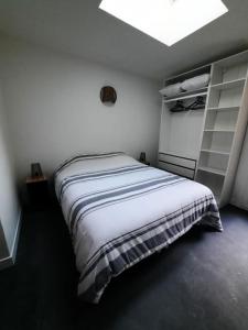 a white bedroom with a bed and a light at Appartement Calais in Calais