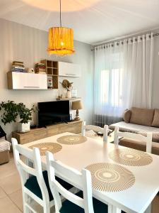 a dining room with a white table and chairs at Holiday apartment, Qerret in Golem