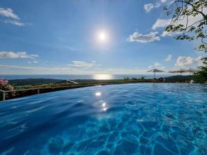 a large swimming pool with a view of the ocean at Vista Ballena in Uvita