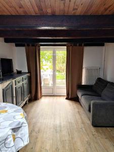 ein Wohnzimmer mit einem Sofa und einem Fenster in der Unterkunft Chez Jul in Bulligny