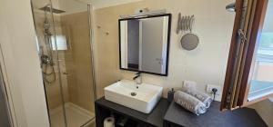 a bathroom with a sink and a shower and a mirror at Casa Belvì - Family Appartement Lugana-Sirmione in San Martino della Battaglia