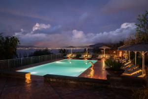 a swimming pool at night with a view of the water at Relais Palazzo del Barone in Sorrento