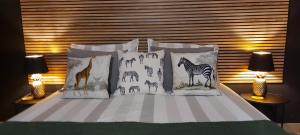 a bed with four pillows with animals on it at Stone House Premium Room in Porriño
