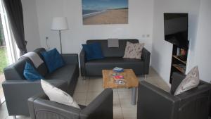 a living room with two couches and a coffee table at -Duinhuisje - voor families & honden nabij strand in Noordwijk