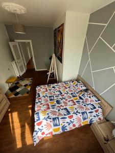 1 dormitorio con 1 cama con un edredón colorido en Océane 2 chambres 100m2 dans Demeure Bourgeoise, 