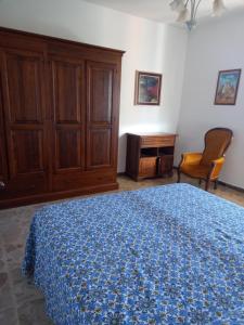 PancoleにあるCasale In Maremmaのベッドルーム1室(ベッド1台、キャビネット、椅子付)