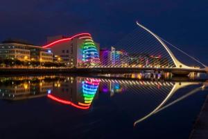 Lovely Home in Kimmage, Dublin في دبلن: جسر فوق هيئة ماء في الليل