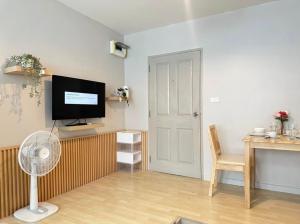 un soggiorno con ventilatore e TV a parete di 1 Bed 1 Bath Apartment a Kathu