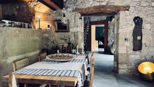 a dining room with a table and a stone wall at Chambres B&B dans Authentique Mas de Village avec Piscine in Robion en Luberon