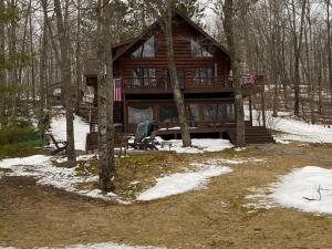 eine Blockhütte im Wald im Schnee in der Unterkunft Grand View Log Cabin in Seeley