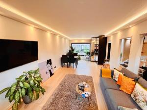 un soggiorno con divano e tavolo di Town house with garden - 1 room with shared bathroom a Bruxelles