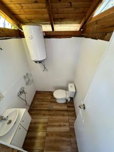 a small bathroom with a toilet and a sink at Каравана Мая in Chernomorets