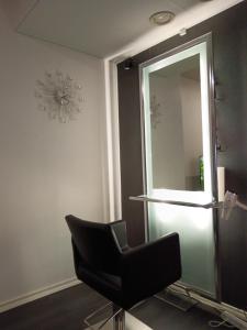 una silla negra en una habitación con espejo en Salonharlekiini, en Lieksa