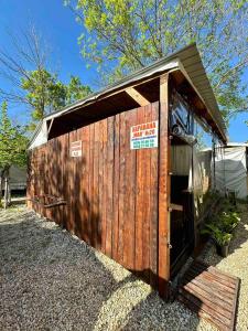 a small woodenshed with a sign on it at Каравана Мая in Chernomorets