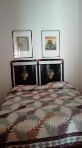 a bed in a bedroom with two pictures on the wall at La grangia in Ferentino
