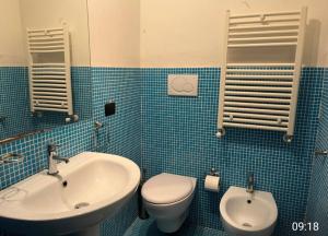 a blue tiled bathroom with a toilet and a sink at Masseria Le Celline in Nardò