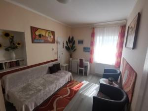 1 dormitorio con 1 cama, mesa y sillas en Tini Apartman, en Balatonfüred