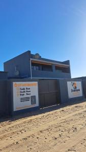 a building with two garage doors on the side of it at Onamungundo Backpackers in Walvis Bay