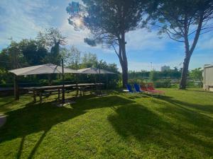 a picnic table with umbrellas and chairs in a yard at Mo&Ma Home in Imola +9 photos