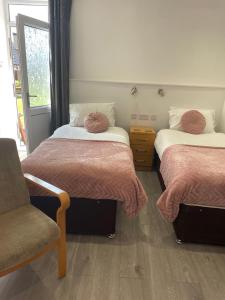 a room with two beds and a chair in it at San Remo Apartments in Blackpool