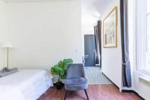 een slaapkamer met een bed en een blauwe stoel bij Elegant and confortable T2 - Ivry & Paris in Ivry-sur-Seine