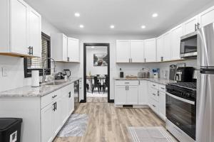 a kitchen with white cabinets and a dining room at Roomy Retreat-Family & Friends 2 King Bed Game Room in Chesterton