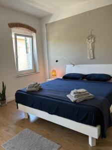 a bedroom with a bed with blue sheets and a window at Sweet Apartment for Friends and Family in Valpolicella in San Pietro in Cariano