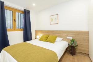 a bedroom with a large bed with yellow pillows at Comfy Stay Barcelona Cathedral in Barcelona