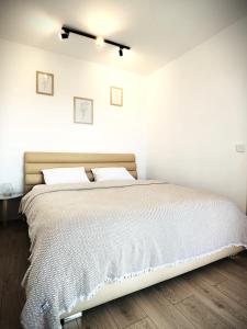 - une chambre avec un grand lit aux murs blancs dans l'établissement Cremene Tower, à Cluj-Napoca