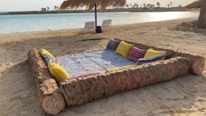 a couch made out of a log on the beach at Holiday Fantzia "For Family" in Ras Matarma