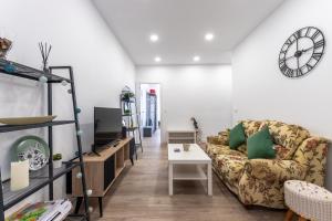 a living room with a couch and a clock on the wall at Apartamento Zubia Barakaldo BEC Bilbao in Barakaldo