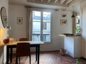 comedor con mesa y ventana en Appartement Paris Marais, en París