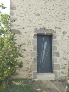 a door in the side of a stone building at Gîte des Trois Cantons in Beaurepaire