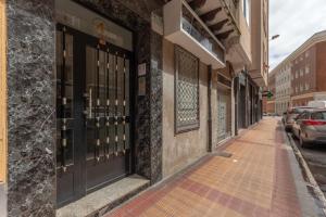 a building with black doors on a street at Apartamento Zubia Barakaldo BEC Bilbao in Barakaldo