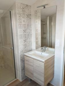 a white bathroom with a sink and a shower at Gîte des Trois Cantons in Beaurepaire