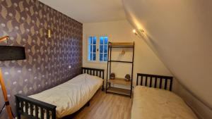 a bedroom with two beds and a window at Maison calme avec Spa et beau paysage, à 40mn des plages in Saint-Jean-de-Livet
