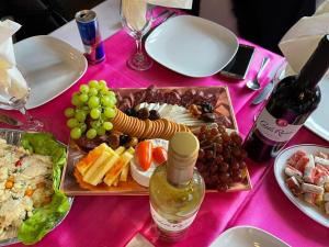 a pink table with a plate of food and wine at An Exquisite Deluxe Room in a Hotel - Free Parking - with access to Resturant - Shisha Bar- Wine Bar in Roundhay