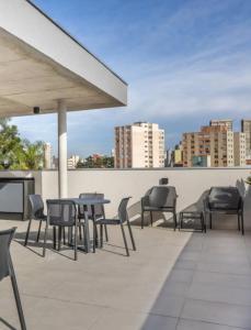 een patio met stoelen en tafels op een dak bij Studio Garden in Curitiba
