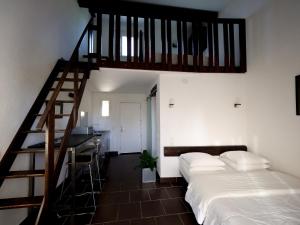 ein Schlafzimmer mit einem Bett und einer Holztreppe in der Unterkunft MAS MLS in Saintes-Maries-de-la-Mer