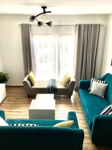 uma sala de estar com dois sofás azuis e uma janela em Quiet Nest Homes em Tatu City