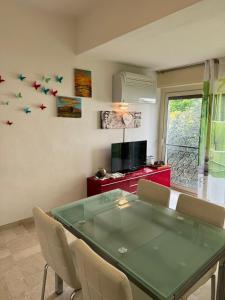 a dining room with a green table and chairs at Appartamento Lido 'with parking space included' in Toscolano Maderno